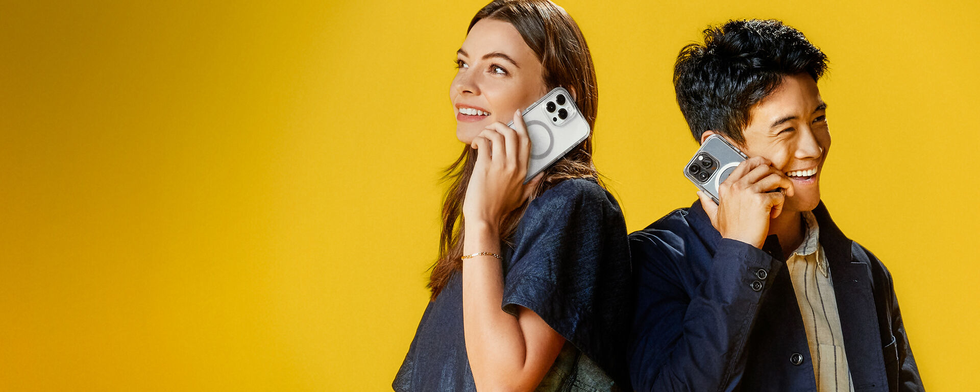 smiling man and woman holding clear MagSafe iPhone cases