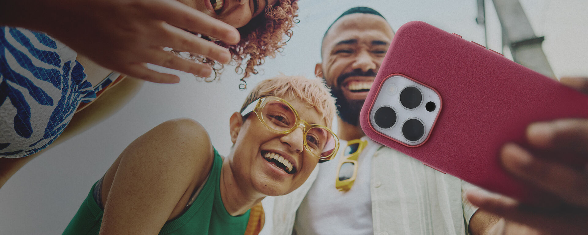 group of friends taking a selfie with an iphone